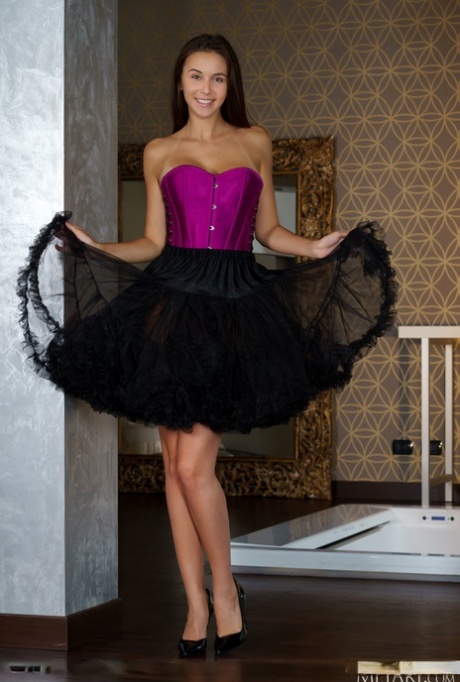 Brunette teen Alisa Amore doffs a corset and tutu skirt to model totally naked