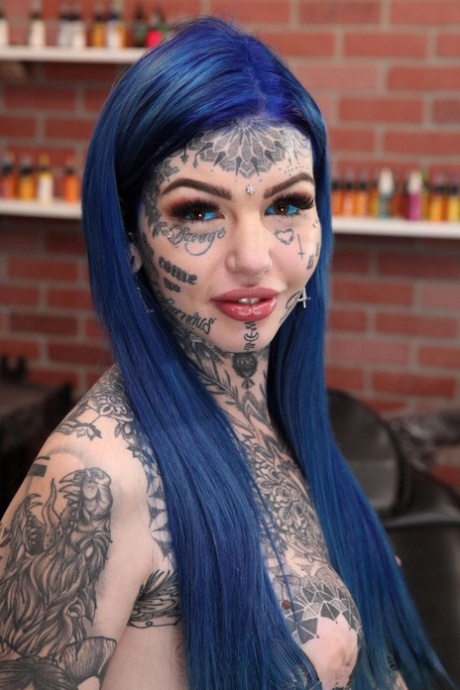 Silně potetovaná dívka Amber Luke pózuje nahá v tetovacím salonu