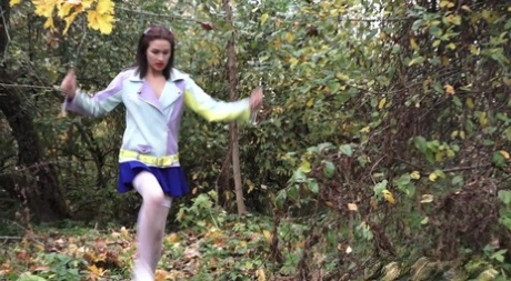 Clothed girl Kristina hitches up her skirt for a pee near a ruined building