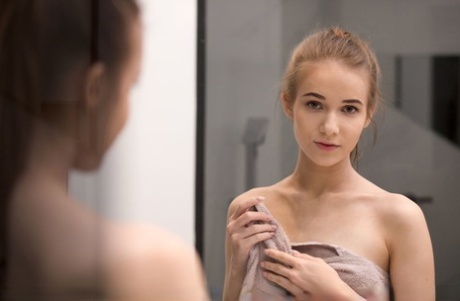 Jong uitziend meisje Jessica Portman toont haar lekkere kontje terwijl ze naakt bij een spiegel staat