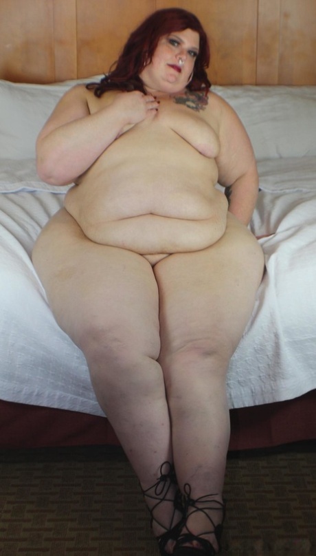 Рыжая SSBBW Nikki Cakes показывает свою массивную задницу, лежа лицом вниз на кровати