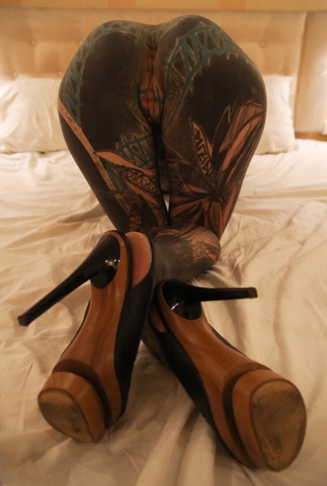 Una ragazza pesantemente tatuata si stringe la figa dopo essersi masturbata con un sex toy