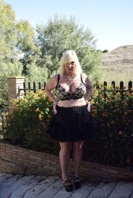 Blonda granny Melody exponerar sin överviktiga kropp i en engelsk trädgård