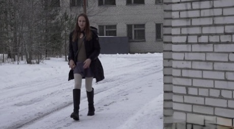 Caucasian girl Valya takes a piss in the snow after ducking behind a building