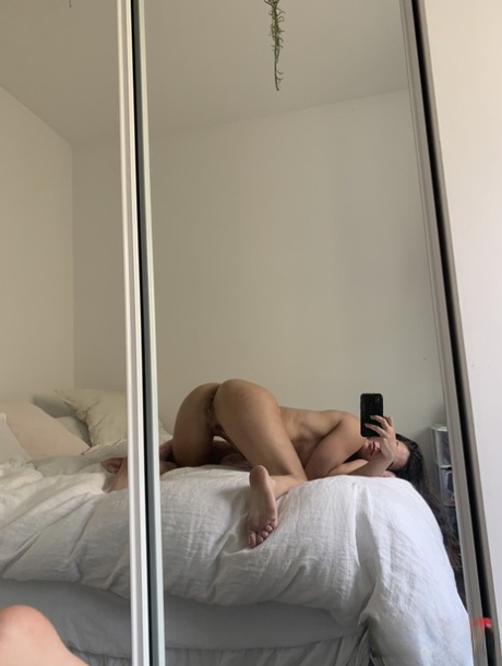 Brunette amateur takes selfies while getting naked in front of a mirror