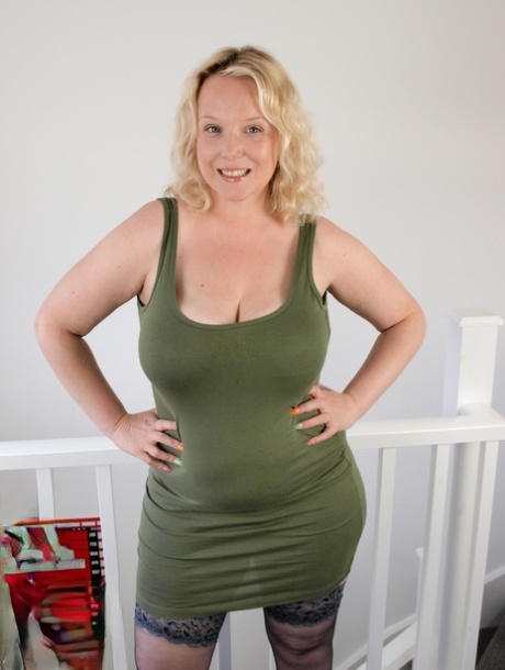 Die fette britische Blondine Sindy Bust zieht ihr Kleid aus und geht nackt in Strümpfen und Fersen