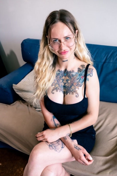 Inked woman Baby Gold gets naked before giving oral sex while wearing glasses