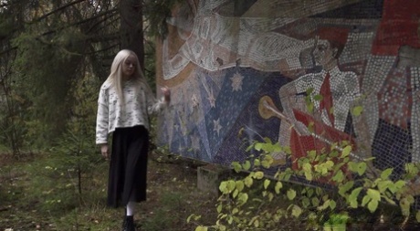 Pěkná blondýnka Eva Barbie močí proti venkovní umělecké instalaci