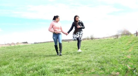 Beste vrienden hurken in een veld om op het gras te pissen