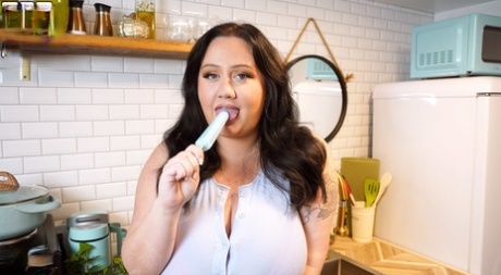 Plump woman Amber Marie sucks on a popsicle while revealing her giant tits