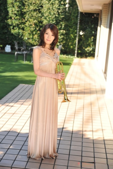 Pretty Japanese girl Anna Kirishima blows a trumpet while getting bare naked