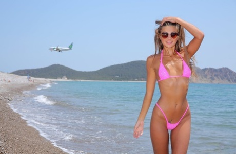 Flatbrystet blondine Maria stripper bikini for å vise frem små pupper på stranden