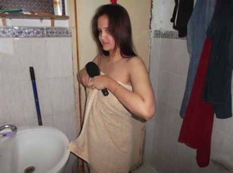 Indisk amatör tar av sig badhandduken och står naken i badrummet