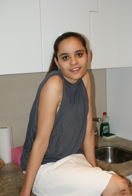 インド人ソロガールJasmineが裸足でスカートを履きながらチューブトップを調整する。