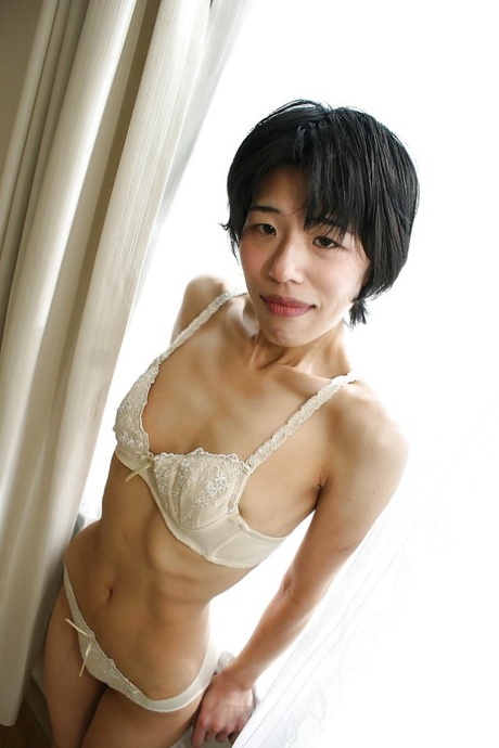 O magricela asiático Shinobu Funayama está a despir a sua lingerie