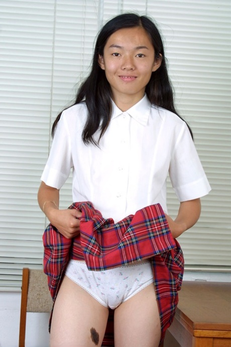 Den kambodsjanske skolejenta Tiffany blinker med hvitt undertøy i skjørtet