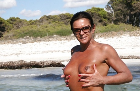 Nøgen britisk kvinde Lady Sarah viser piercet moden fisse udendørs på stranden