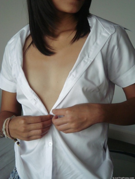 Geile aziatische babe stript en masturbeert haar kut met een dildo