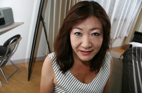 Asiatisk granny Michiko Okawa klär av sig och exponerar sin håriga fitta i närbild