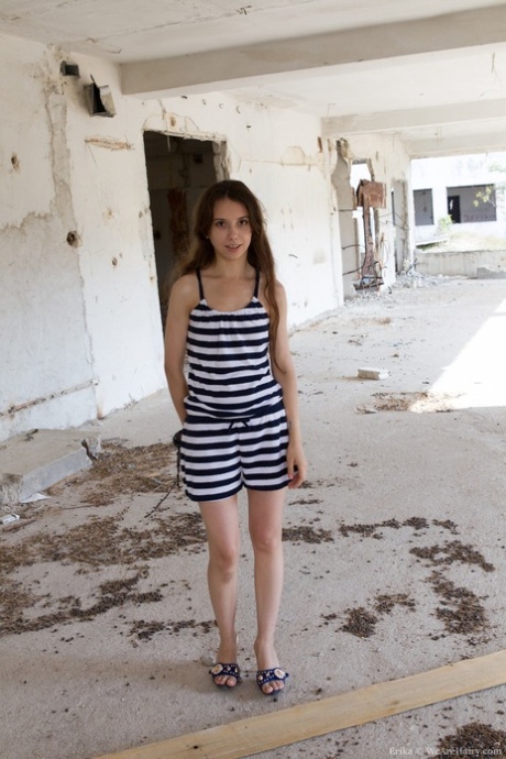 Petite Erika flaunts her tiny tits and hairy muff in an abandoned building