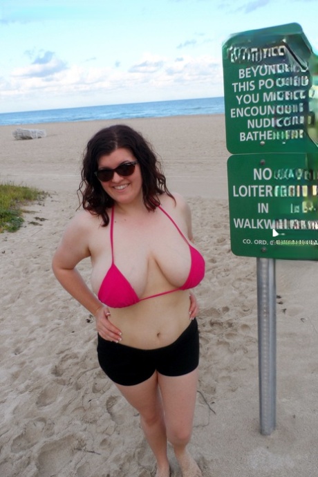 Une fille épaisse et solitaire dévoile ses seins pour une journée à la plage nue.