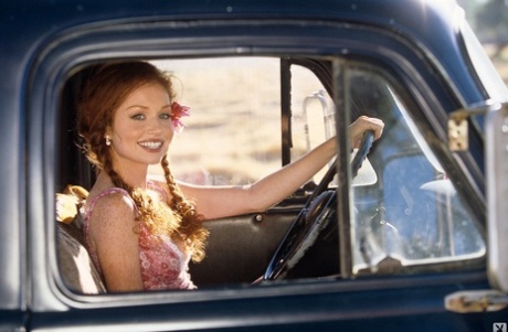 Irresistible redhead beauty Scarlett Keegan shows natural tits in farm truck