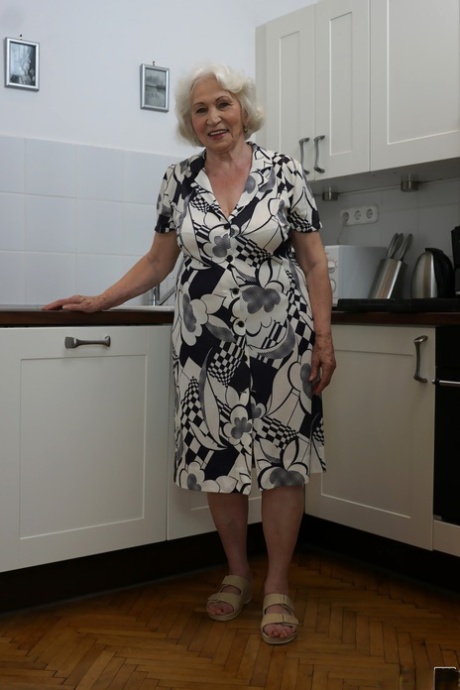 La vecchia nonnina bionda di nome Norma mostra le tette in cucina