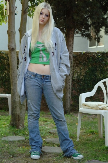 Bleg blond teenager skræller sine grønne tråde udendørs for at afsløre faste bryster og finger