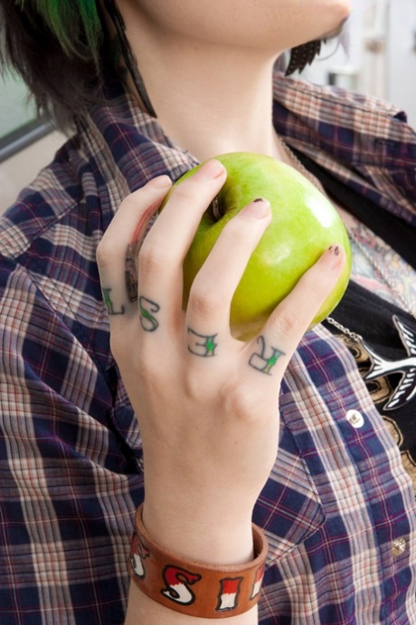 La ragazza bianca Miss Genocide mangia una mela mentre si spoglia