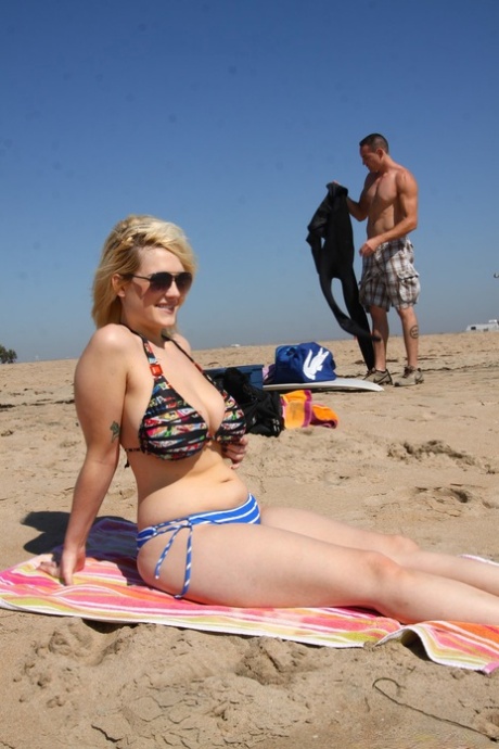 Knubbiga blonda solbadaren Siri visar sina stora bröst i bikini på stranden