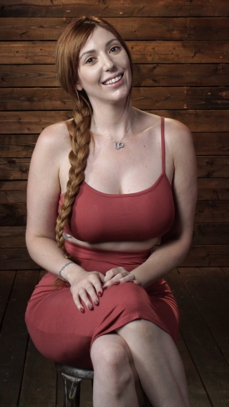 La voluptueuse MILF rousse Lauren Phillips est attachée et jouée sur une table.