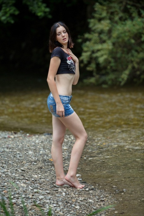 Curvy teen babe Cordoba strips in a stream and touches her perfect body