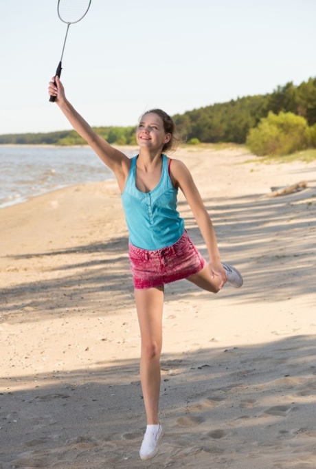 Tiener Faina Bona stript naakt & poseert terwijl ze badminton speelt op het strand