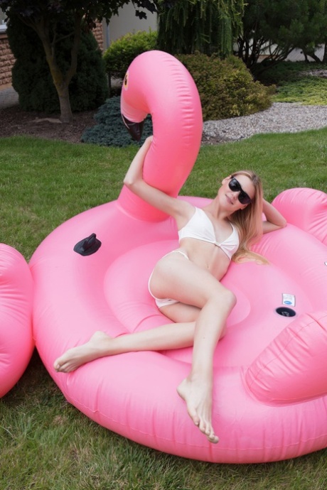 Celestine, une adolescente glamour, pose nue dans un flotteur flamant rose.