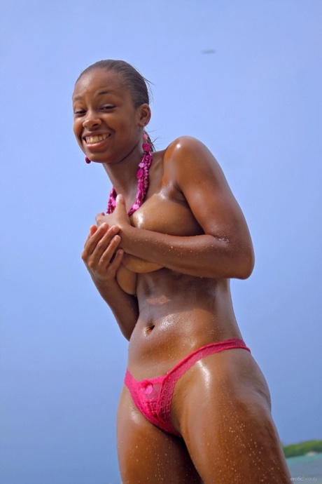 Ebony girl Tierra exponerar sina stora naturliga bröst medan hon strippar i havet