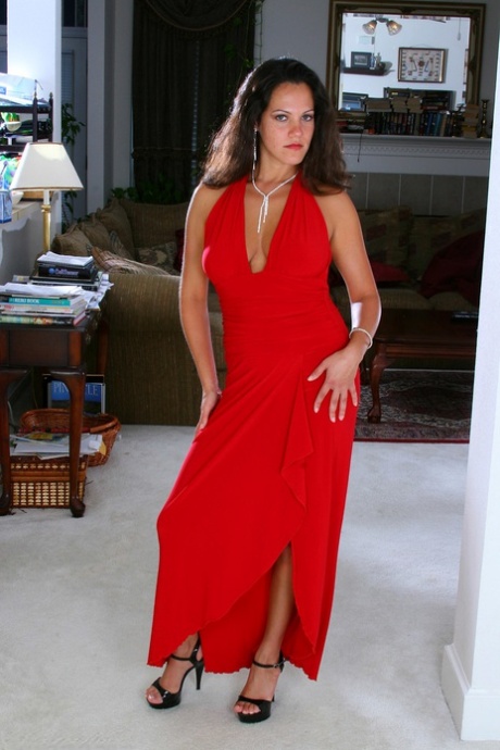 Veronica F, MILF brune en robe rouge, expose ses gros seins et sa chatte savoureuse.