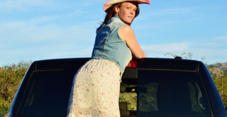 Mature cowgirl Emily Rain lifts her skirt up and shows her meaty pussy outside