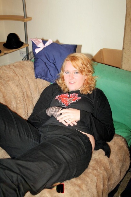 Redheaded fatty strips her sweatshirt and shows her cleavage in a black bra