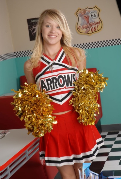 Den søte college-blondinen Tegan Summers poserer i cheerleader-antrekk på en kafé.