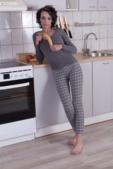 Den sexy amatøren Cleo Dream tar av seg pyjamasen og blotter busken på kjøkkenet.