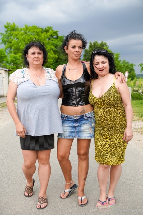 Tre gamla damer med stora bröst tar av sig kläderna och leker med en kuk