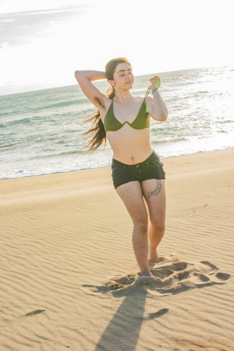 La bella Kisa Fae si spoglia del suo bikini verde in spiaggia e mostra il suo corpo peloso