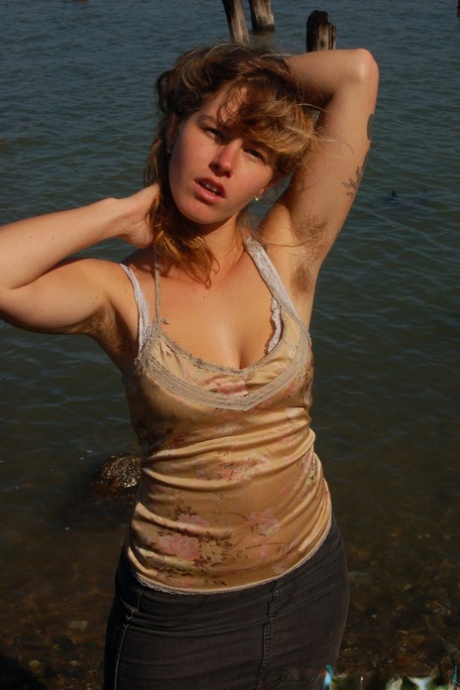 Развратная молодая шлюшка Лила раздевается у воды и обнажает свое волосатое тело