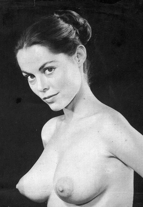 Une star du porno vintage avec de gros seins pose nue et en collants chauds