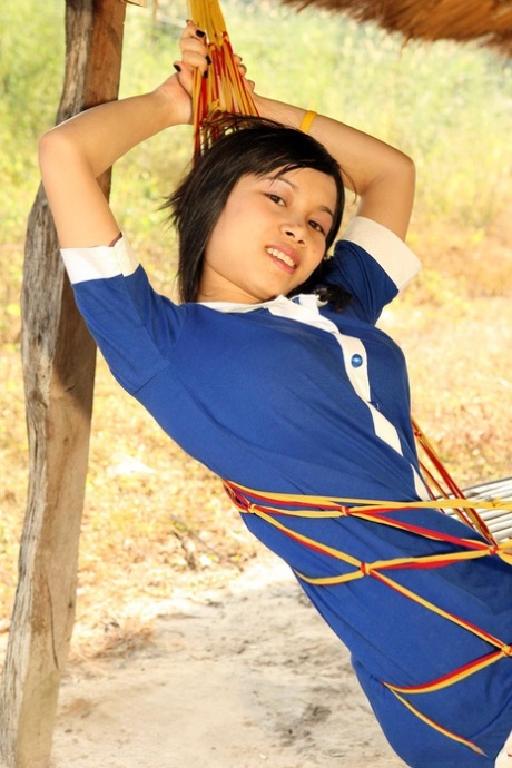 La sexy asiática Kung se quita la ropa para mostrar su apetecible coño hinchado