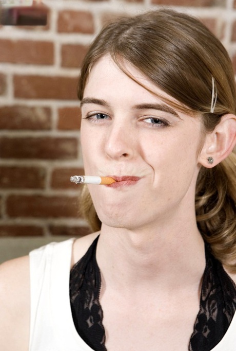 Skinny Transen Mandy Mitchell raucht eine Zigarette und Streifen auf einer Couch