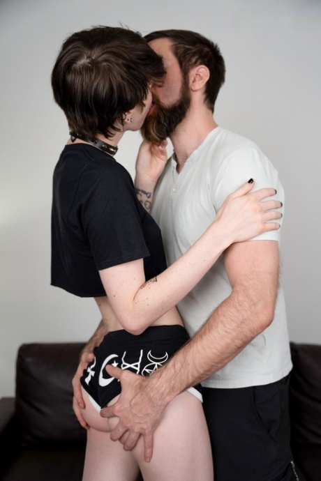 Tynn emo-shemale kysser en skjeggete homse og tar pikken hans bakfra