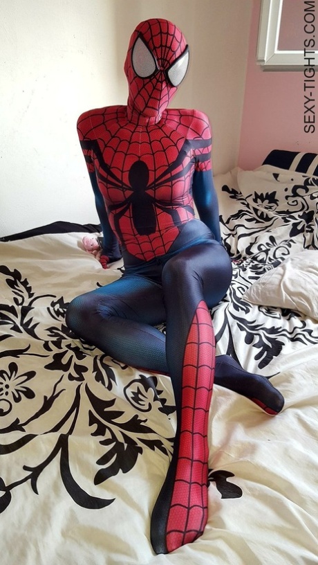 Une cosplayeuse montre ses fesses serrées dans un costume de Spiderman sur son lit.