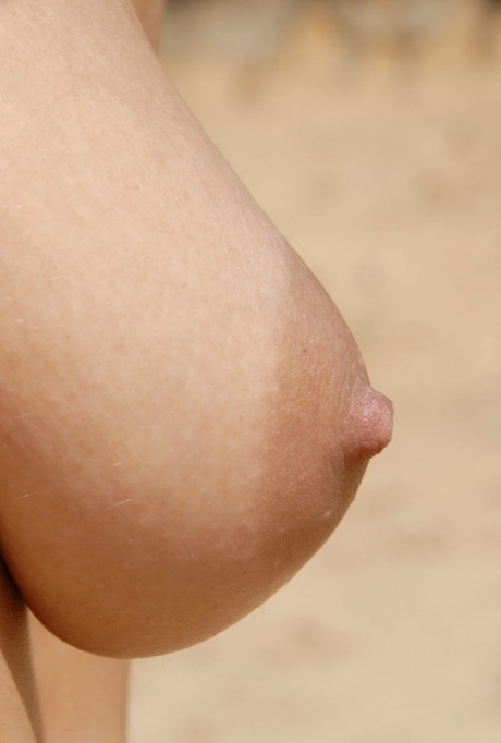 Tonåriga Stany poserar naken på en sandstrand och visar sin håriga fitta på nära håll