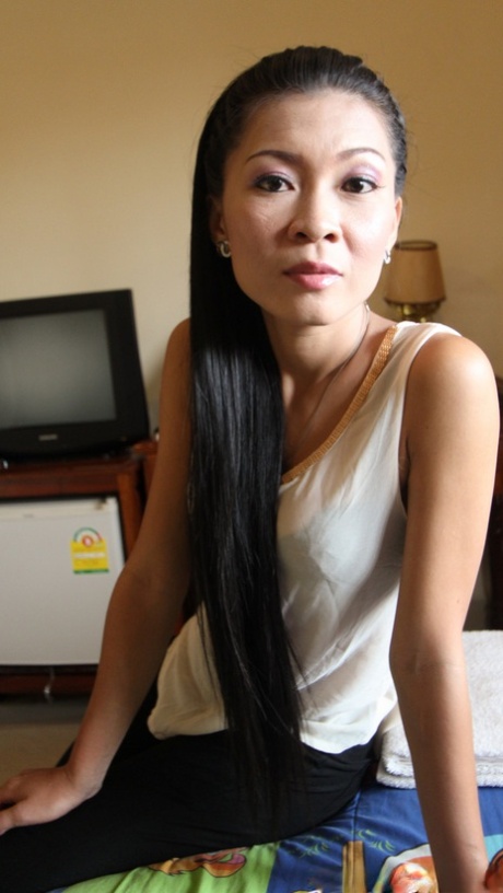 Tynn asiatisk Gi viser frem sin hårete fitte mens hun kler av seg for sex